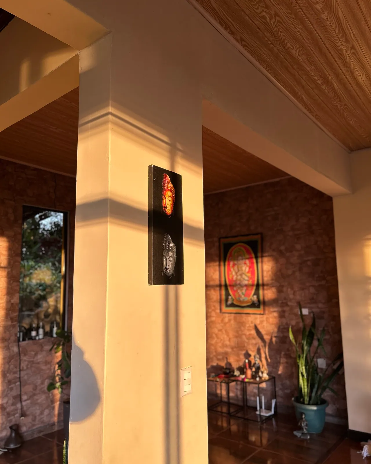 Luz dorada sobre las columnas del salón y, al fondo, el tapiz de Ganesha